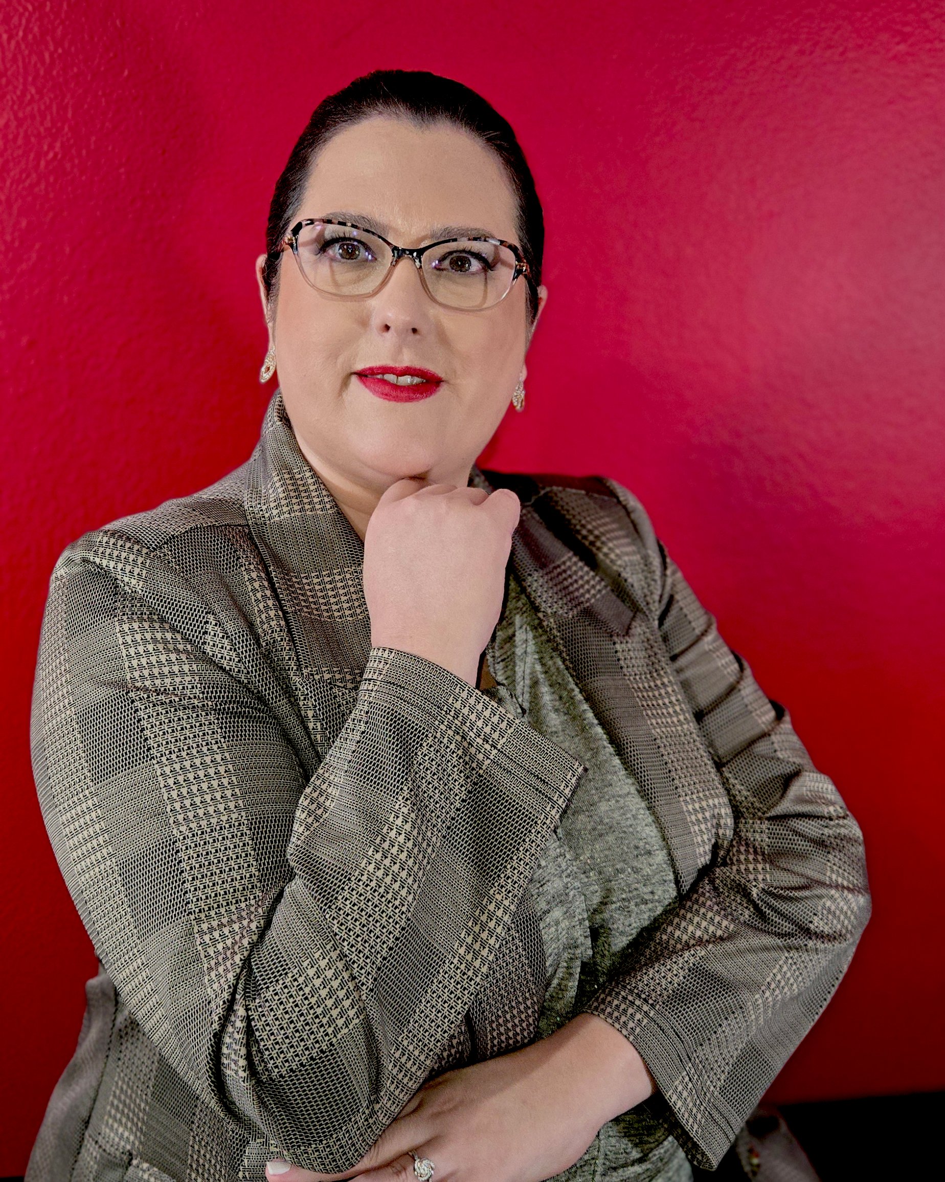 Tatiana Lautner de blazer dourado, com a mão sob o queixo